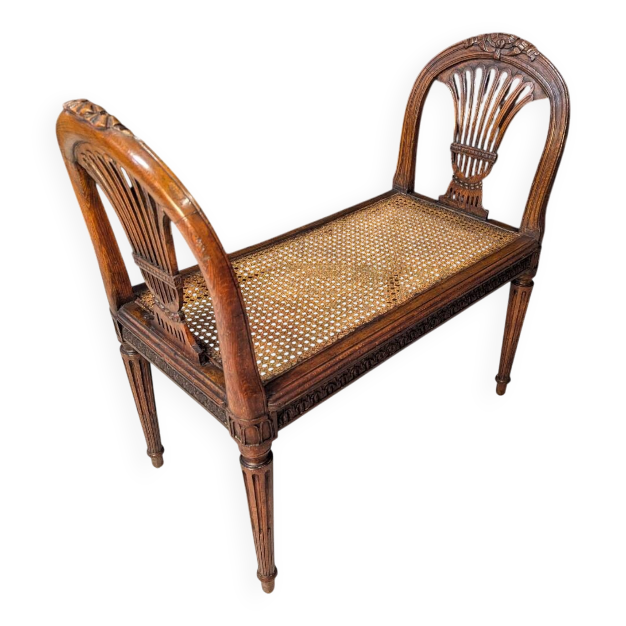 Louis XVI bench in walnut with cane seating.
