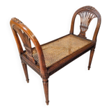 Louis XVI bench in walnut with cane seating.
