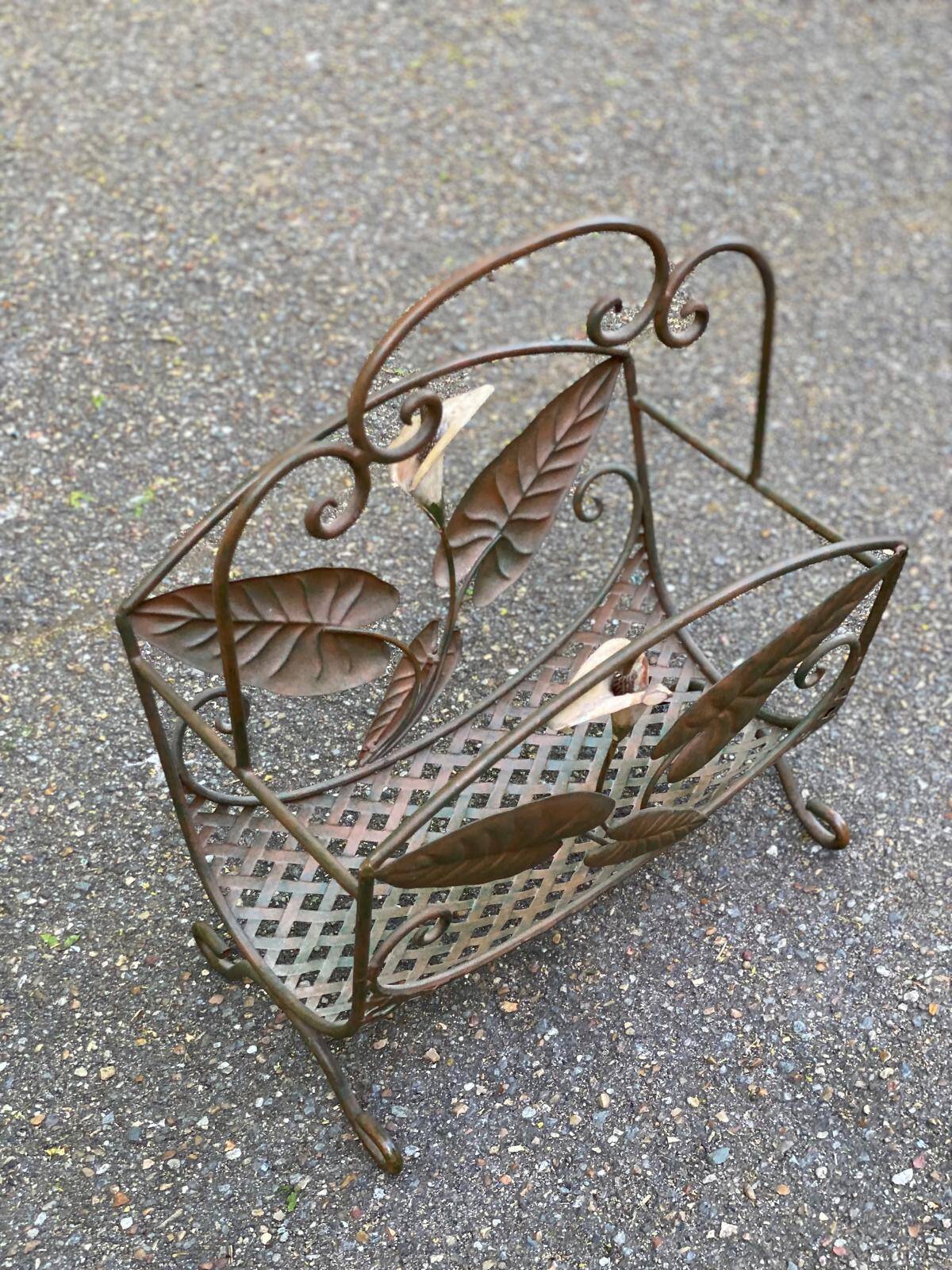 Vintage wrought iron magazine rack with flower pattern.