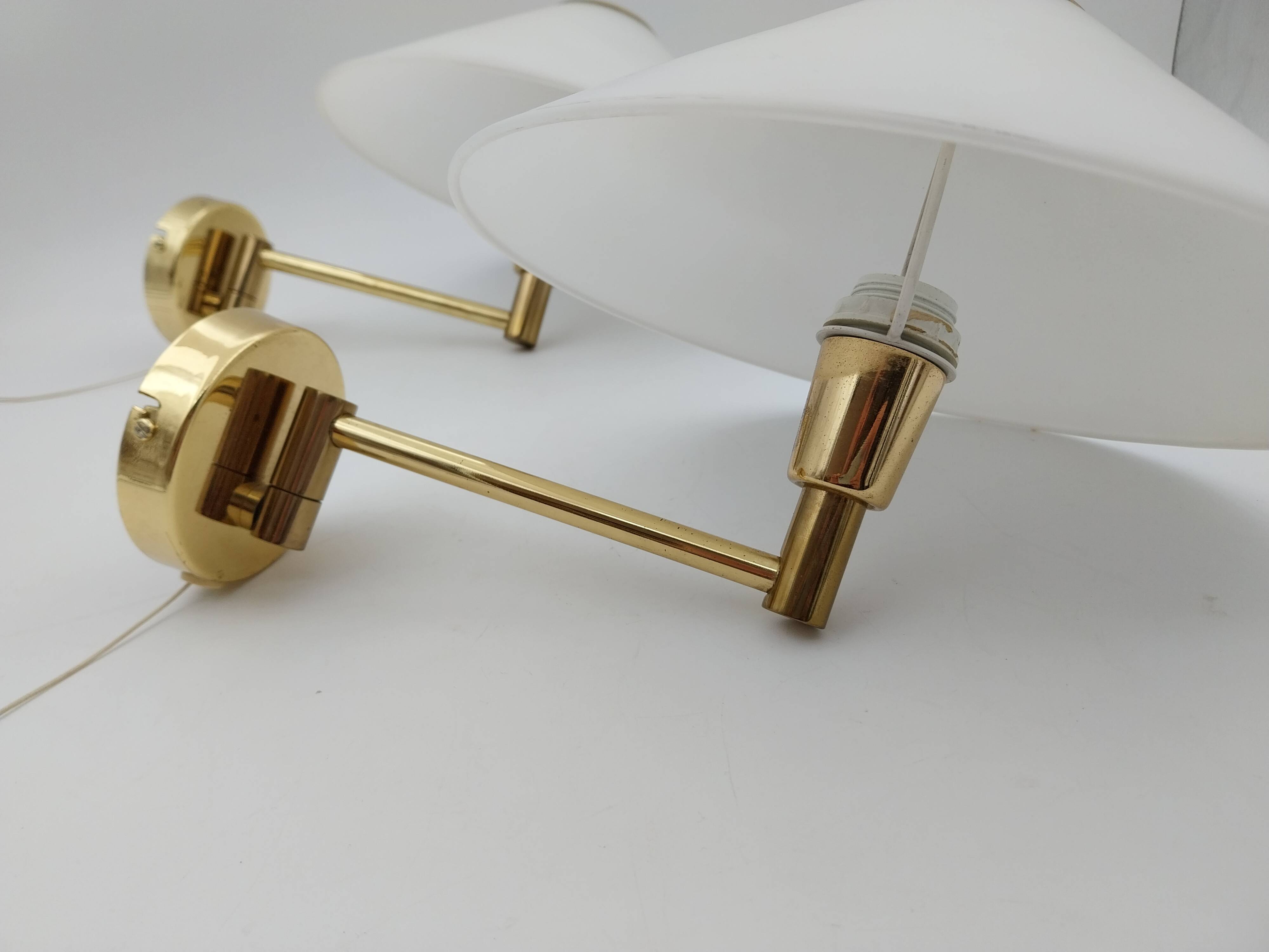 Pair of articulated arm wall lights in brass with opaline globe
