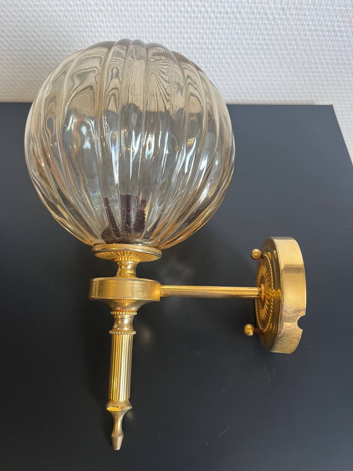 Brass wall light and bubbled glass globe