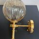 Brass wall light and bubbled glass globe