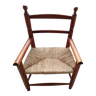 Children's wooden armchair and straw-covered seat.