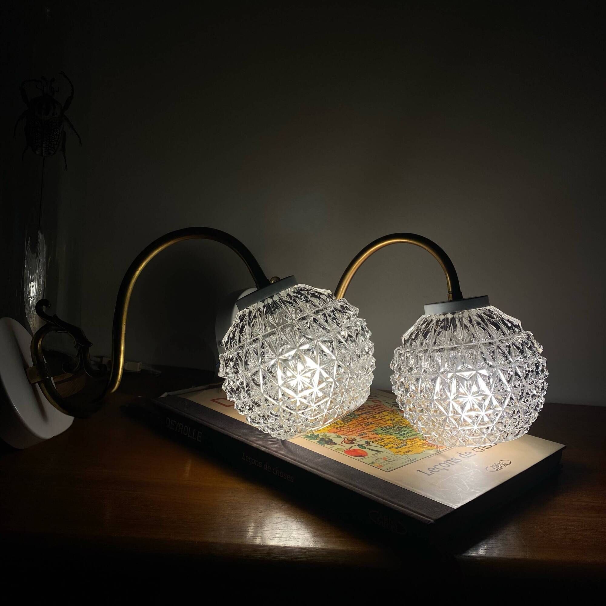 Large pair of brass swan neck wall lights with transparent glass globes.