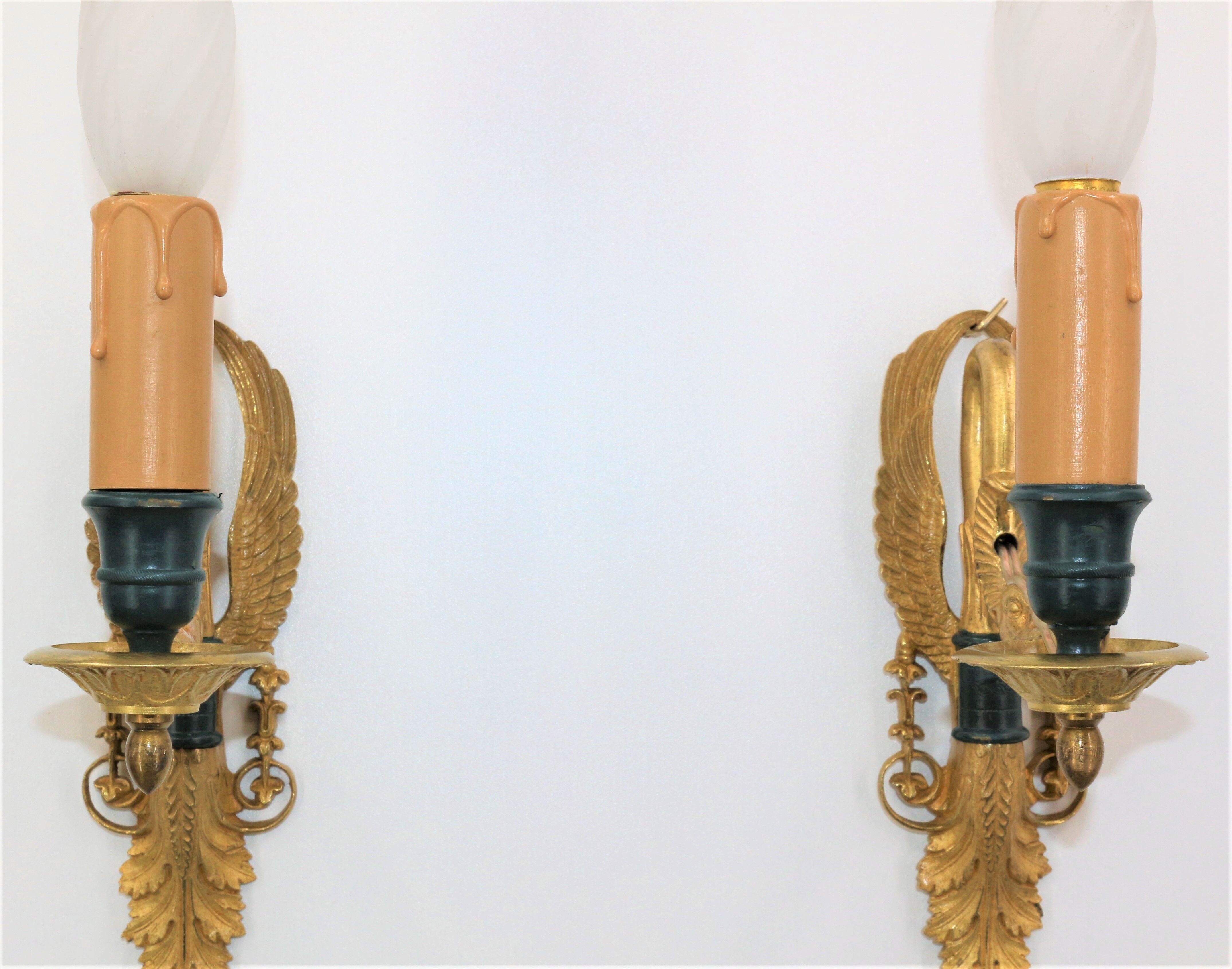 Pair of golden bronze wall lamps in triumphant empire swan style