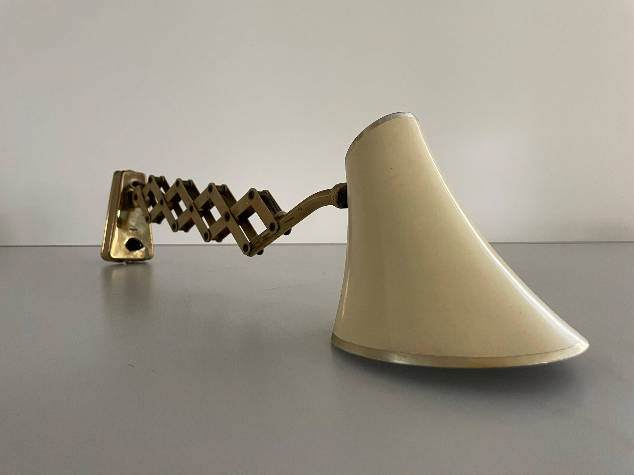 Cream metal and brass wall lamp with scissors design by Karl Lang for SIS Licht, 1950s, Germany.