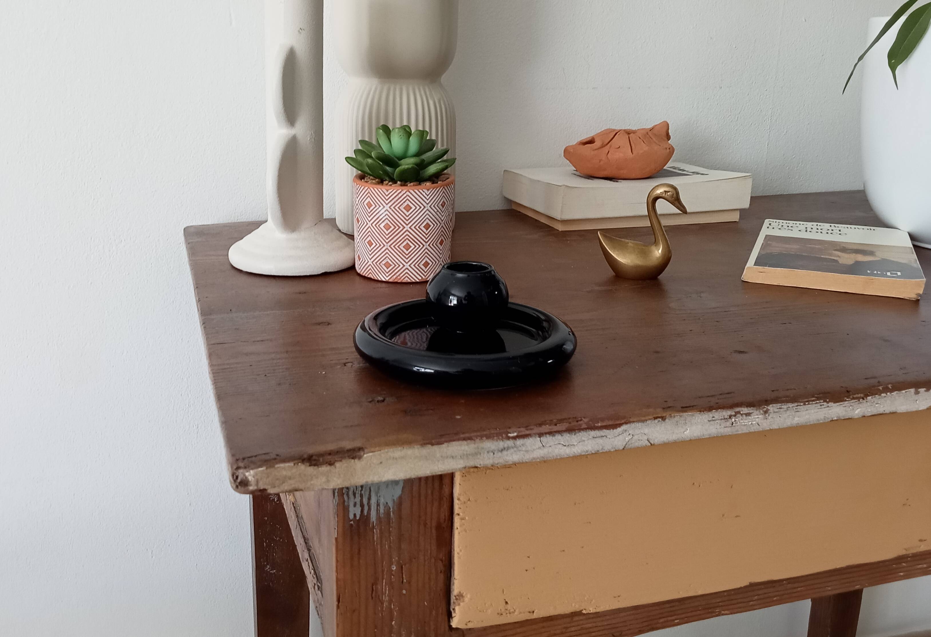 Vintage black ceramic candle holder on a bowl