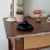 Vintage black ceramic candle holder on a bowl