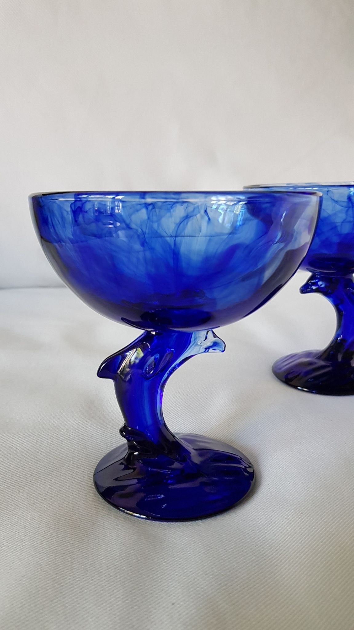 Set of 2 dolphin dessert cups in blue glass.