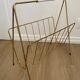 Vintage magazine rack in gold metal with white plastic handle. 60s.