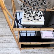 Rattan bookshelf and black glasses
