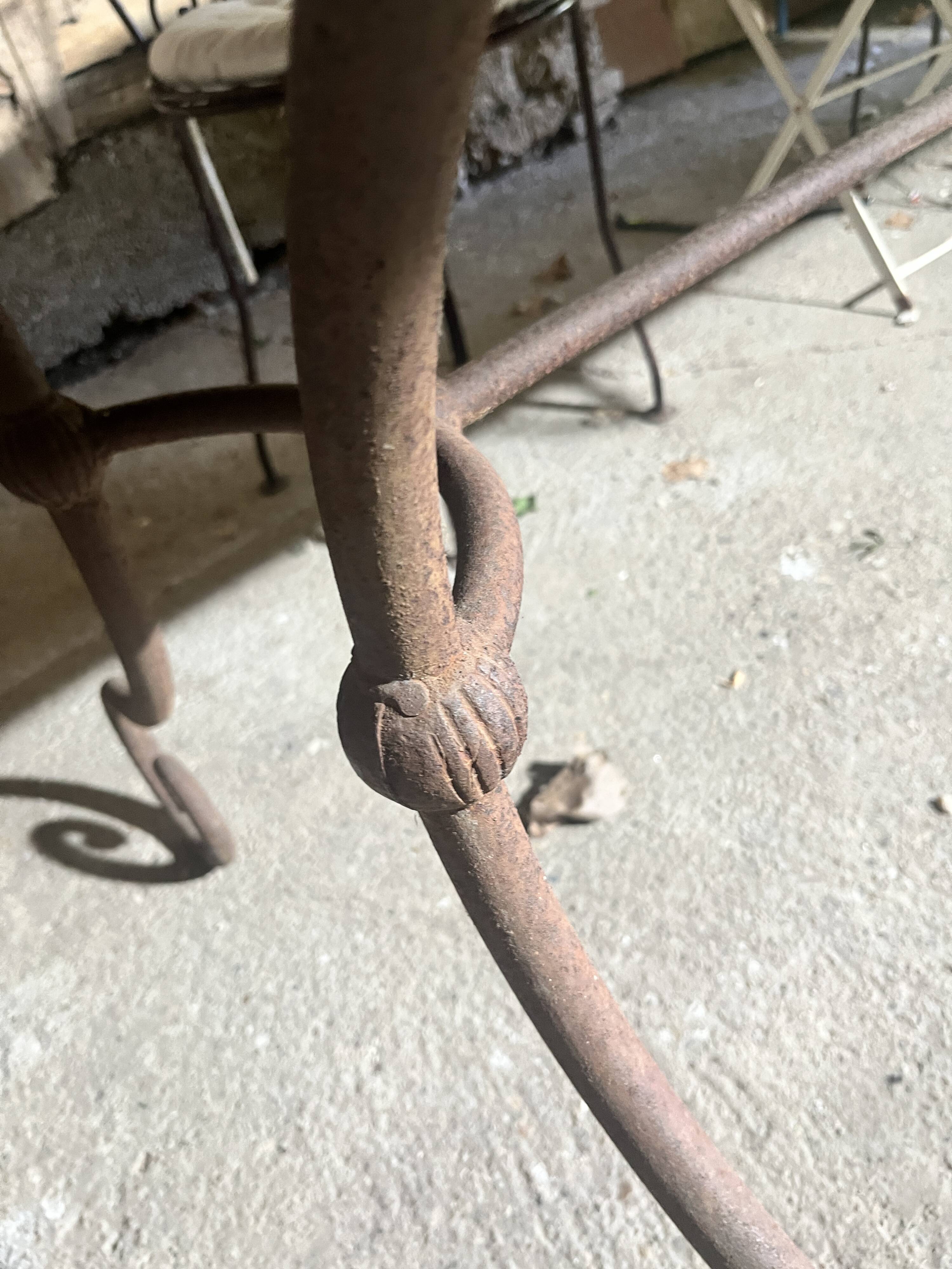 Old wrought iron table and its armchairs and chairs for outdoor use.