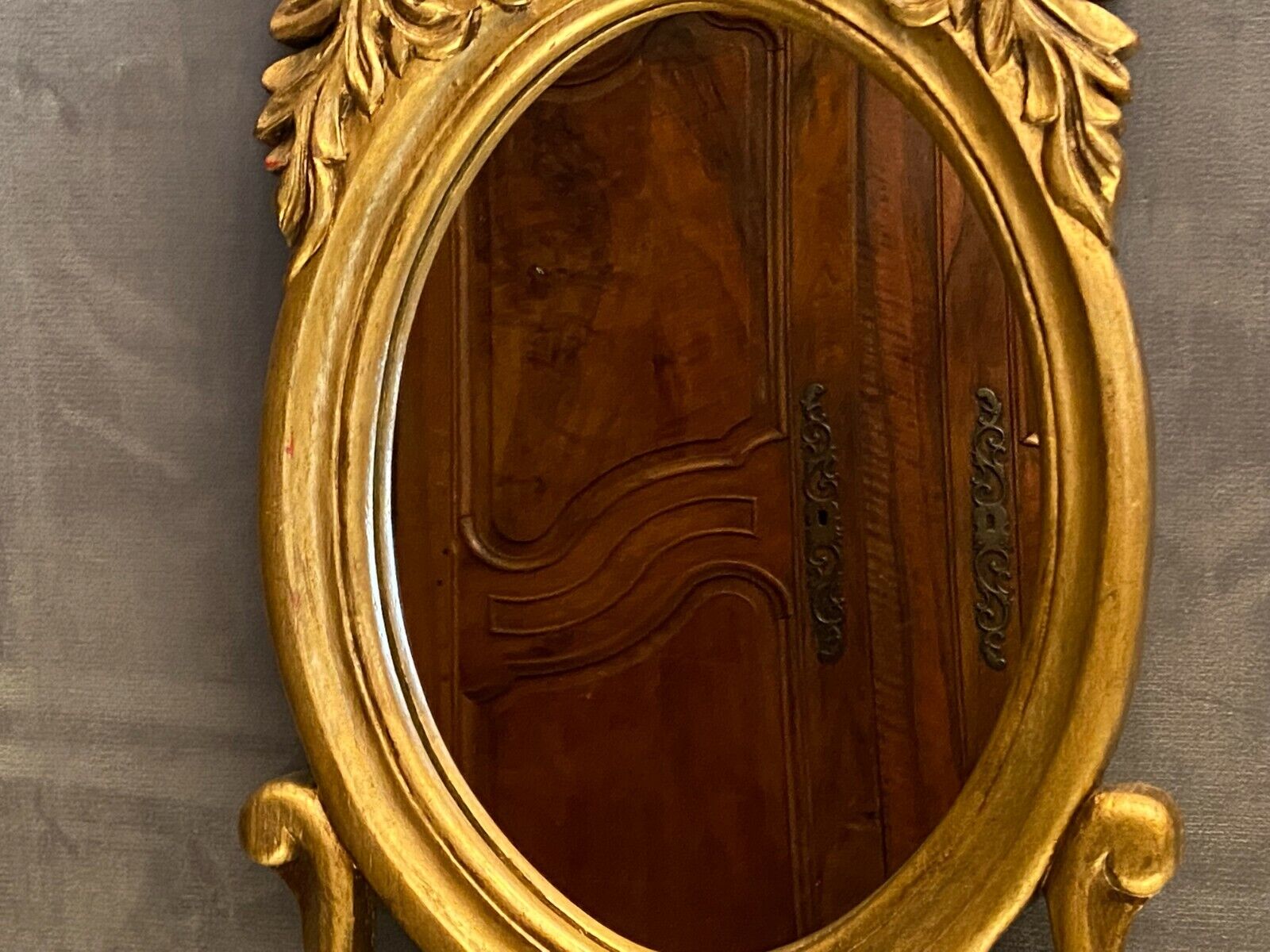 Oval view mirror in gilded wood with leafy decoration in Regency style