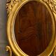 Oval view mirror in gilded wood with leafy decoration in Regency style