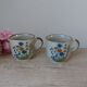Set of two speckled stoneware mugs with small wildflower bohemian retro design.