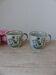 Set of two speckled stoneware mugs with small wildflower bohemian retro design.