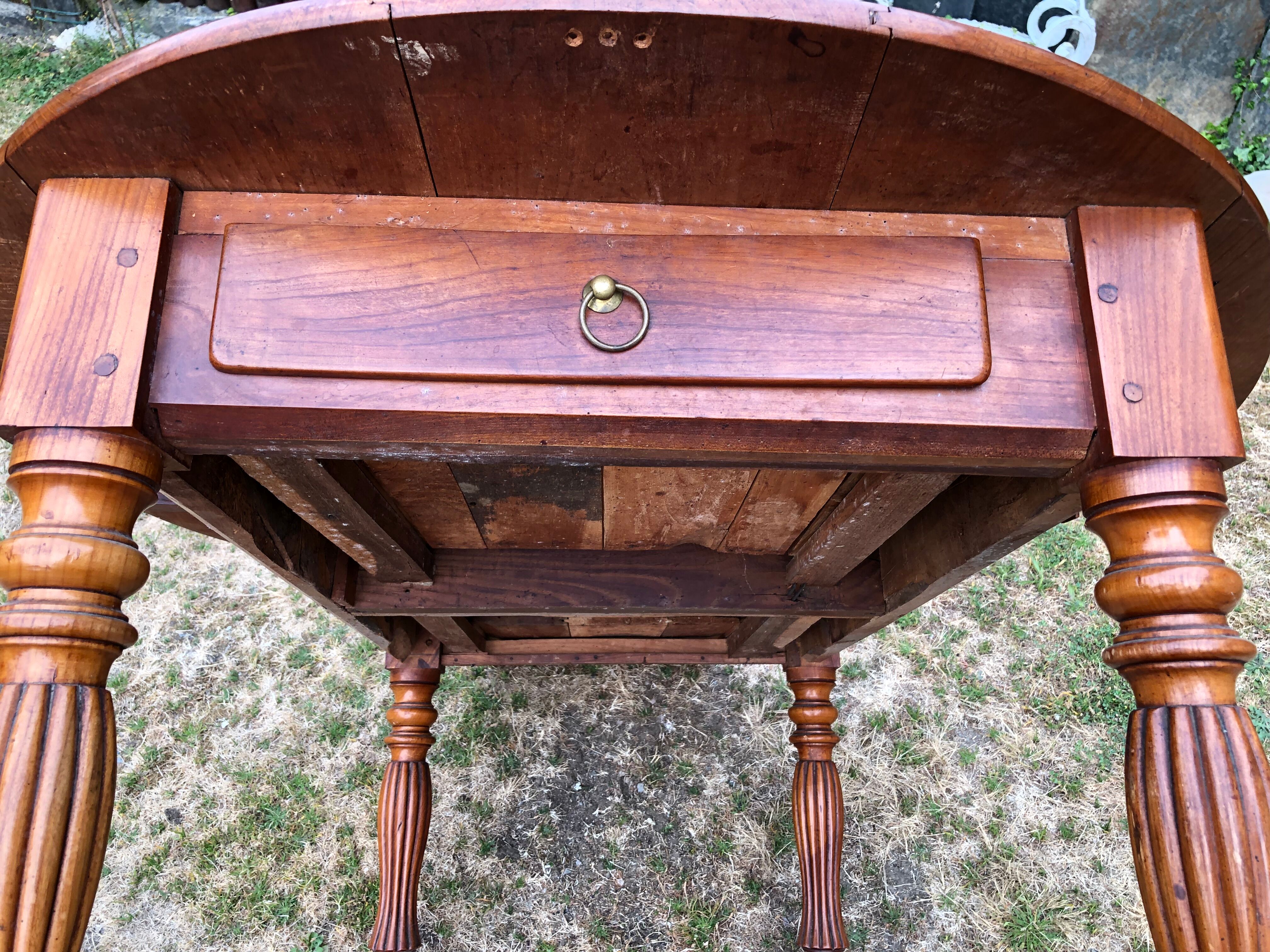 Louis Philippe oval drop-leaf table in solid cherry wood with 2 drawers.