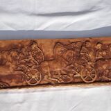 Bas-relief plaster scene of horses and a cart.