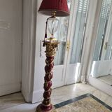 red and gold wooden column in the shape of a vine foot topped with a lamp