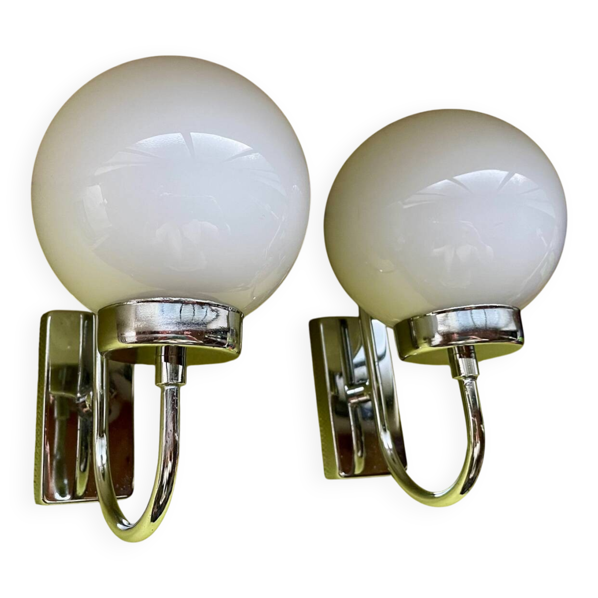 Pair of chrome metal wall lights with white glass globe.