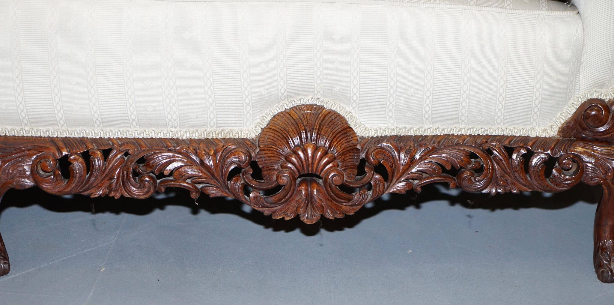 Three-seater canapé carved from solid walnut with claw feet.