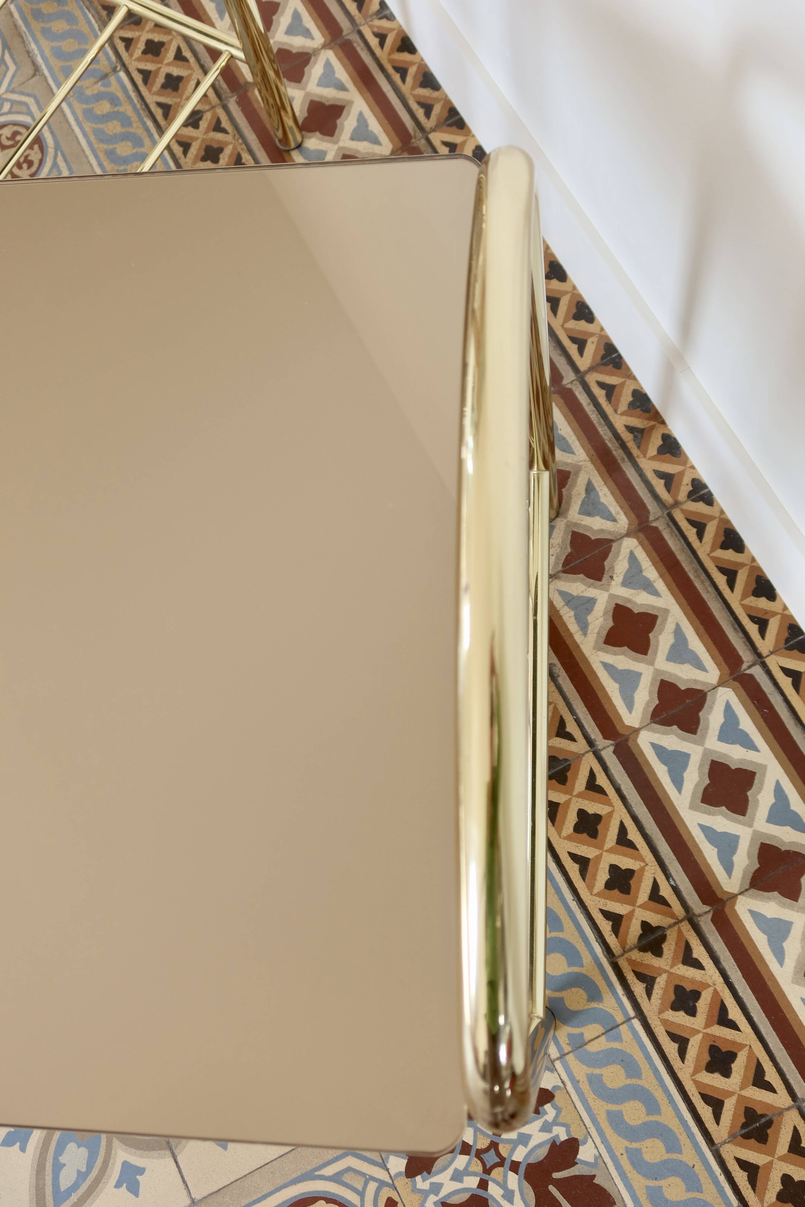 Pair of bedside tables with gold metal and mirrored glass top.