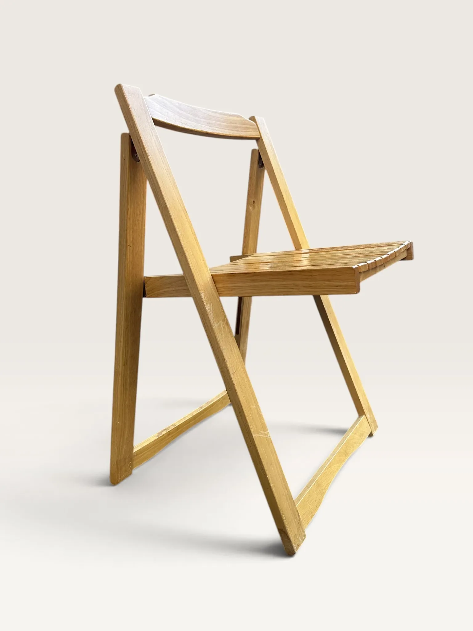Blonde wooden folding chair in the style of Aldo Jacober.
