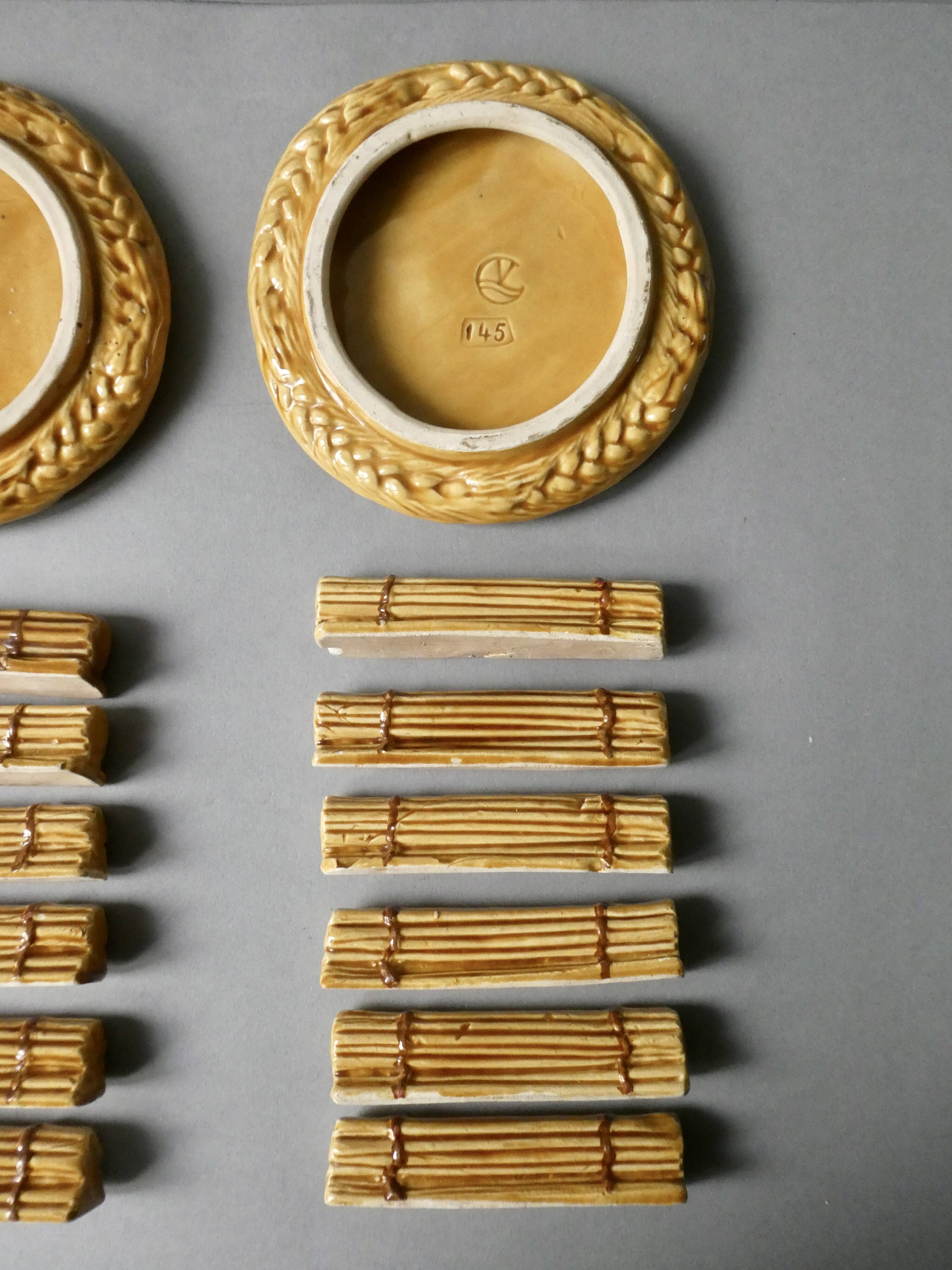 12 knife rests and 2 bottle coasters in earthenware