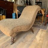 Antique brown recamier armchair in fabric and wood, S-shaped silhouette and turned legs.
