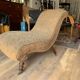 Antique brown recamier armchair in fabric and wood, S-shaped silhouette and turned legs.