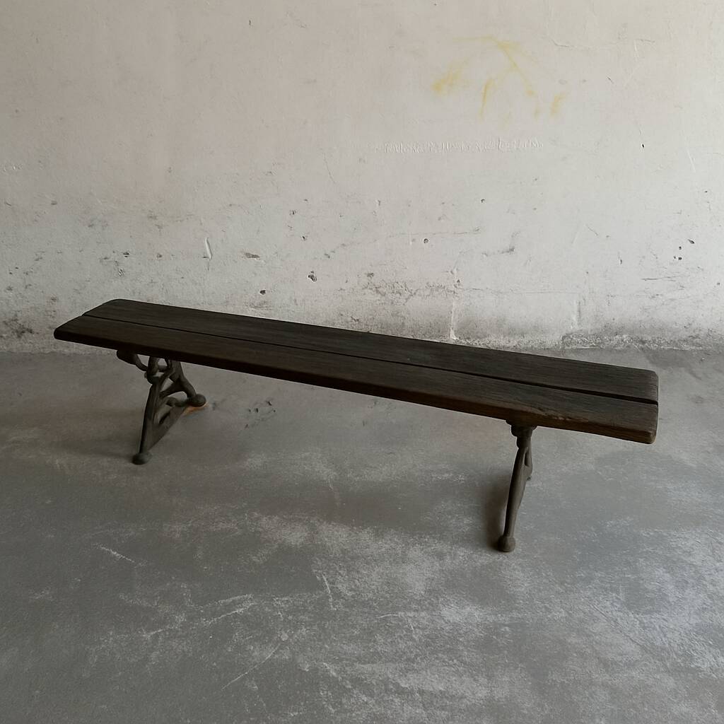 Dark brown wood and black cast-iron antique garden bench with weathered solid-wood seat