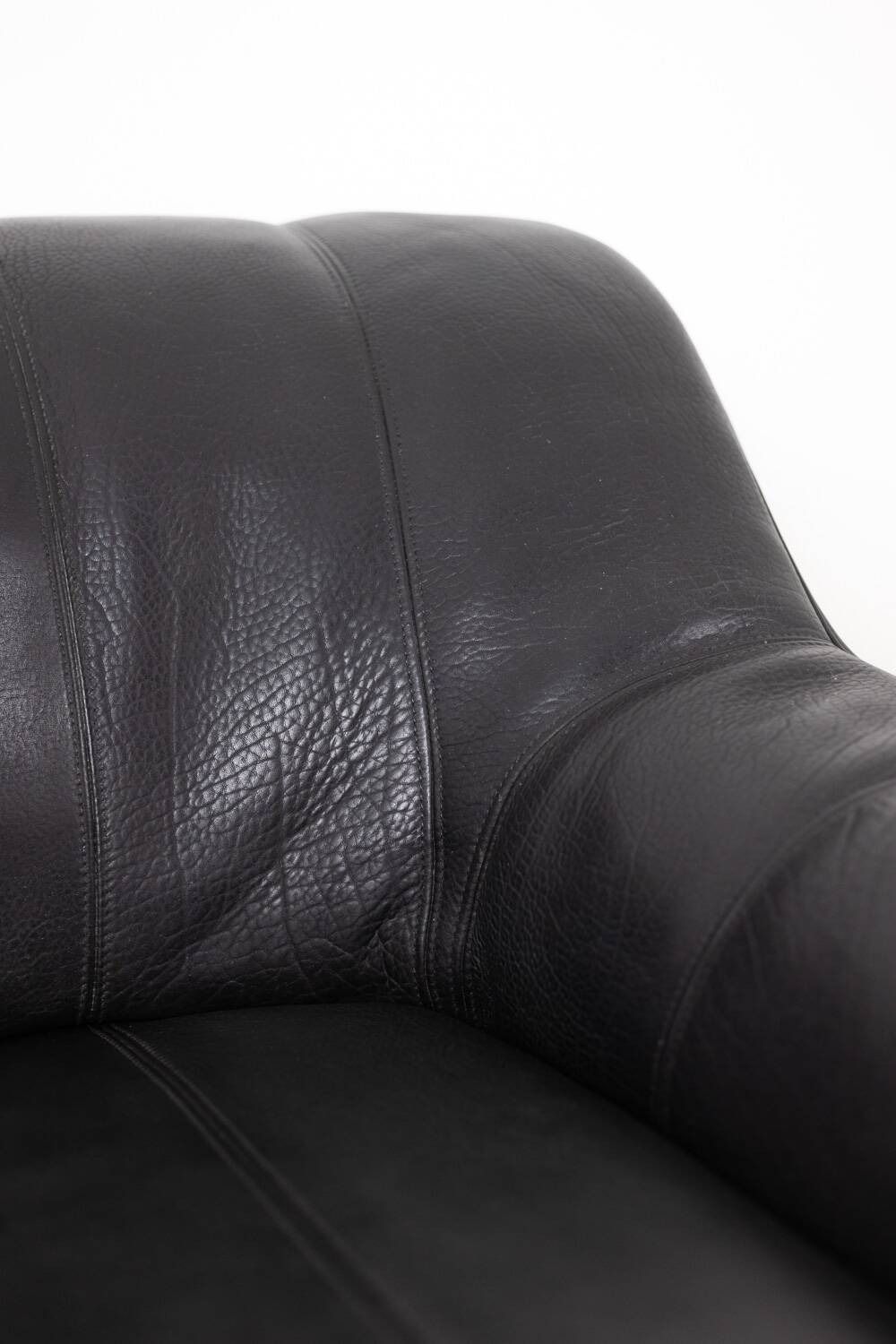 Maison De Sede. Armchair and its ottoman in black leather. 1970s.