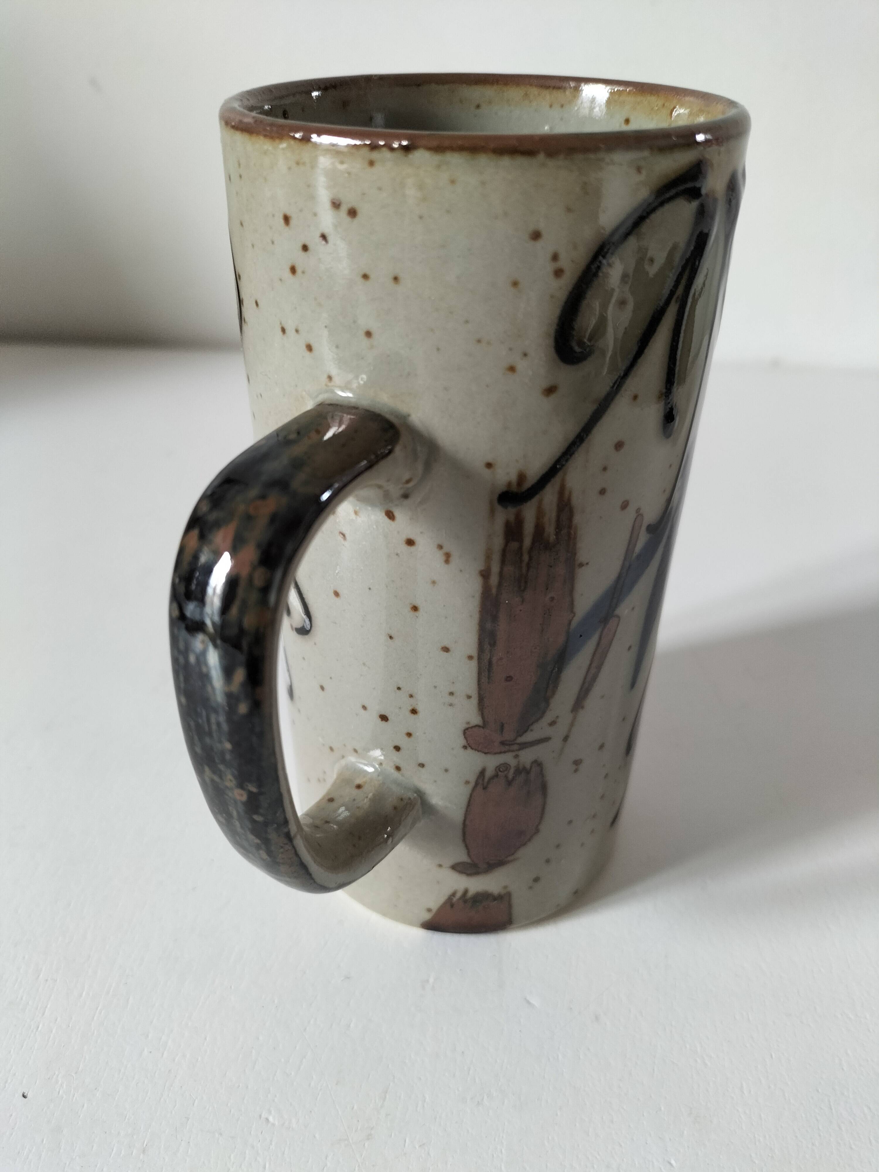 Glazed stoneware mug with free decoration, vintage pottery work.