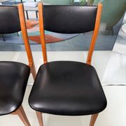 4 Scandinavian chairs in teak and black faux leather.