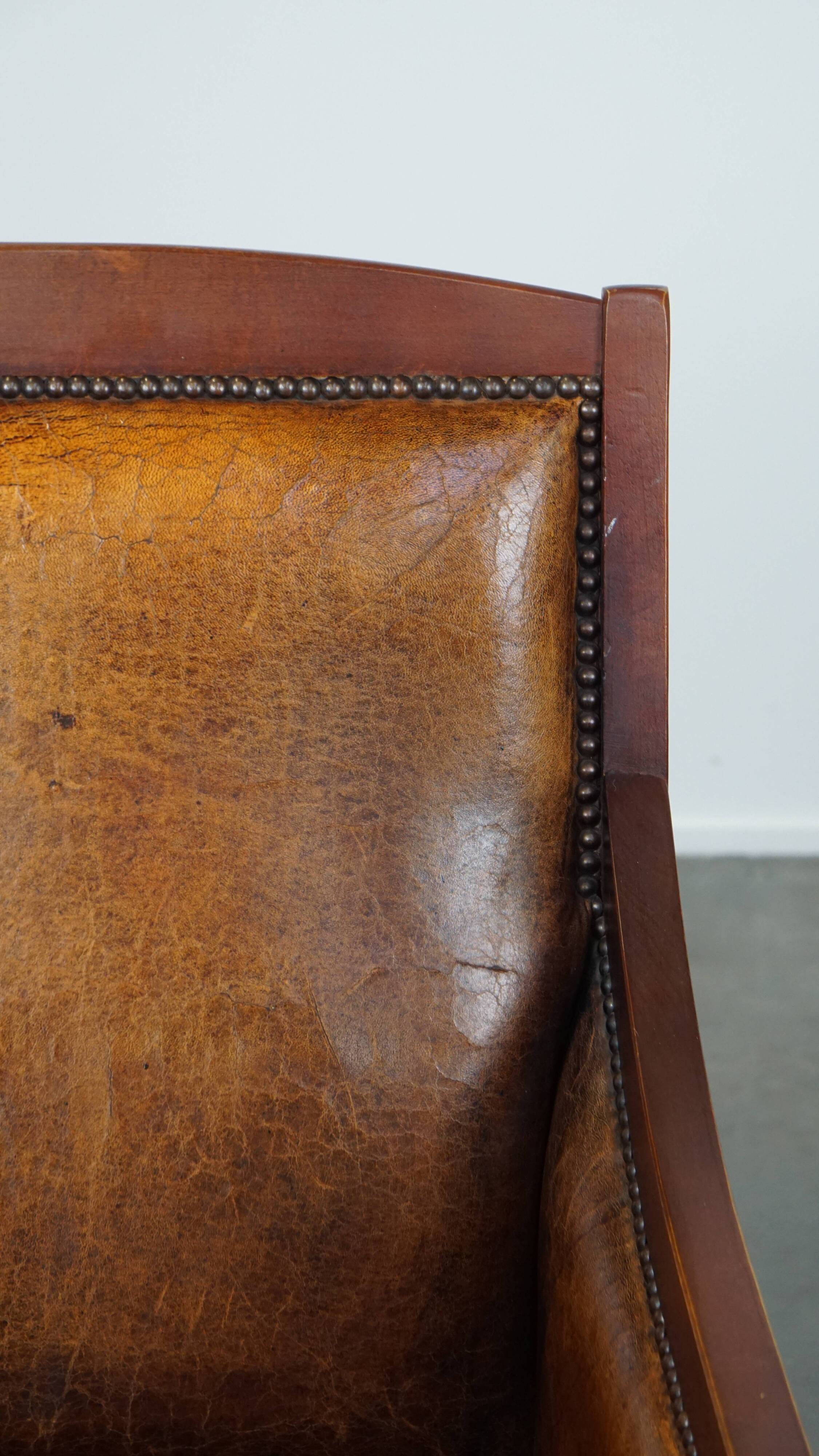 Sheepskin and wooden vintage Art Deco design armchair in a cognac color