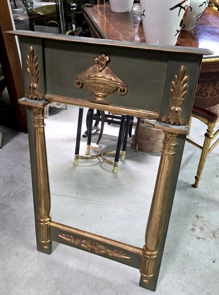 Empire-style mirror in deep green lacquered wood richly enhanced.