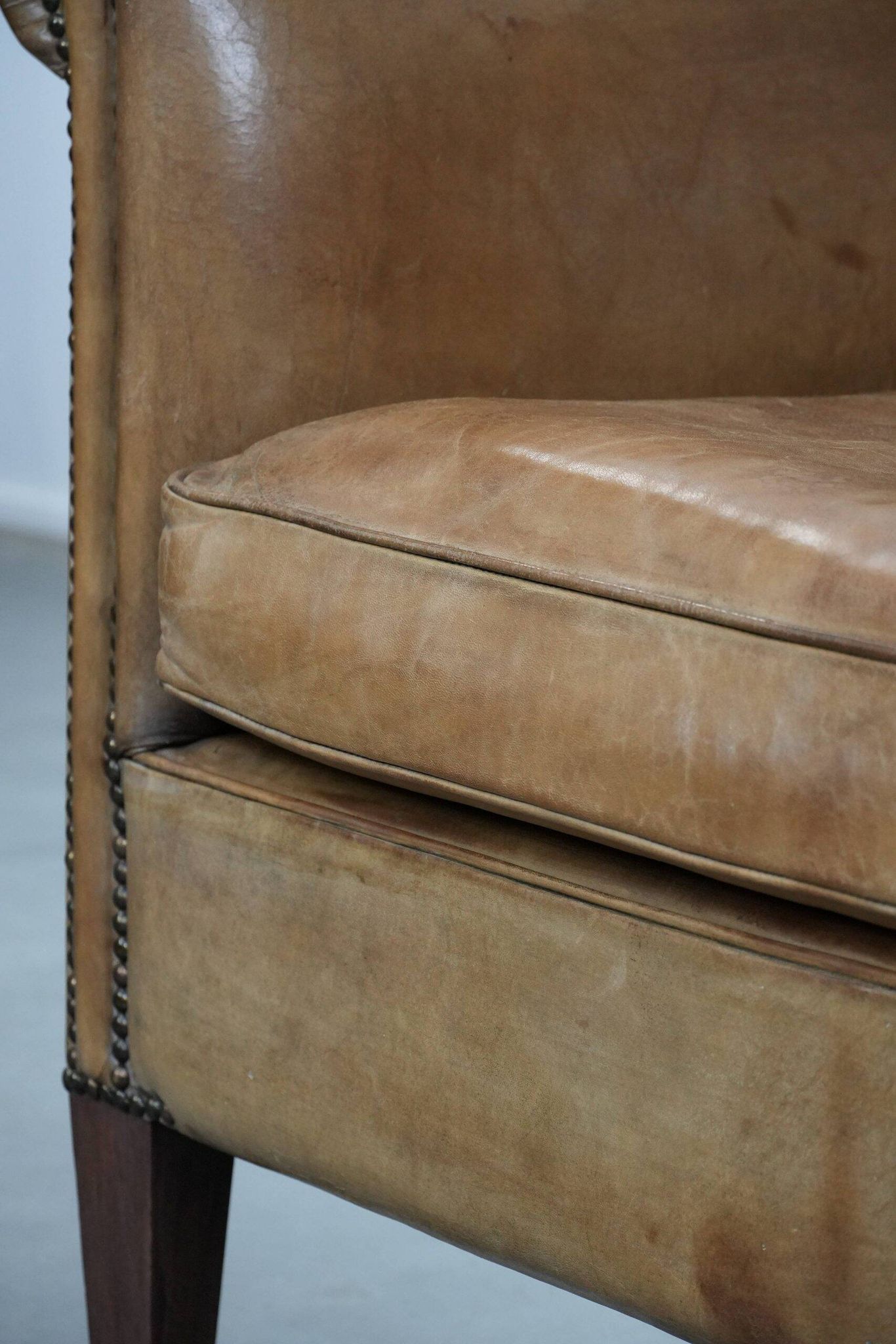 Characterful club chair made of sheepskin leather with light cognac colours