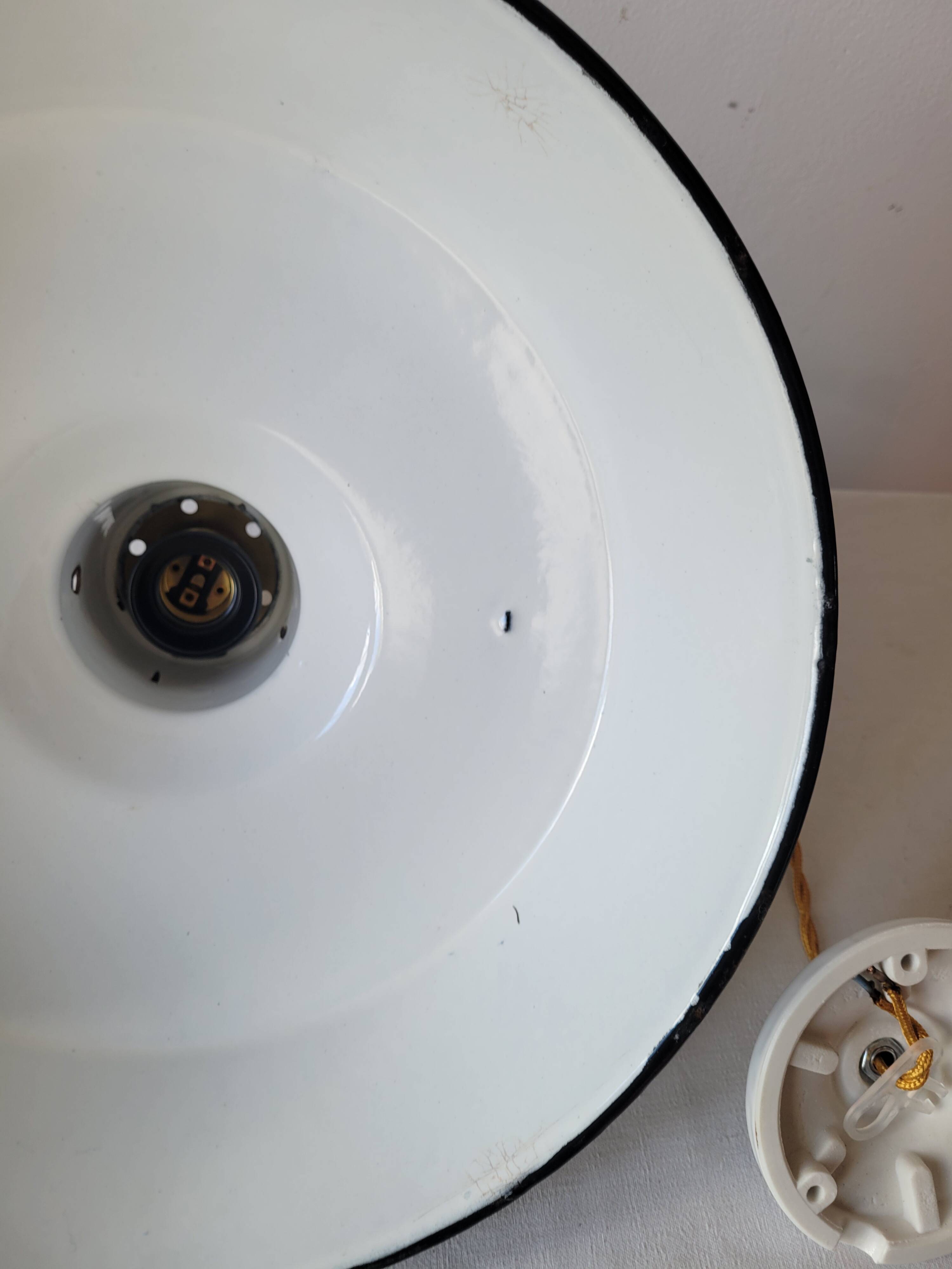 Suspension in enamelled sheet metal and brass