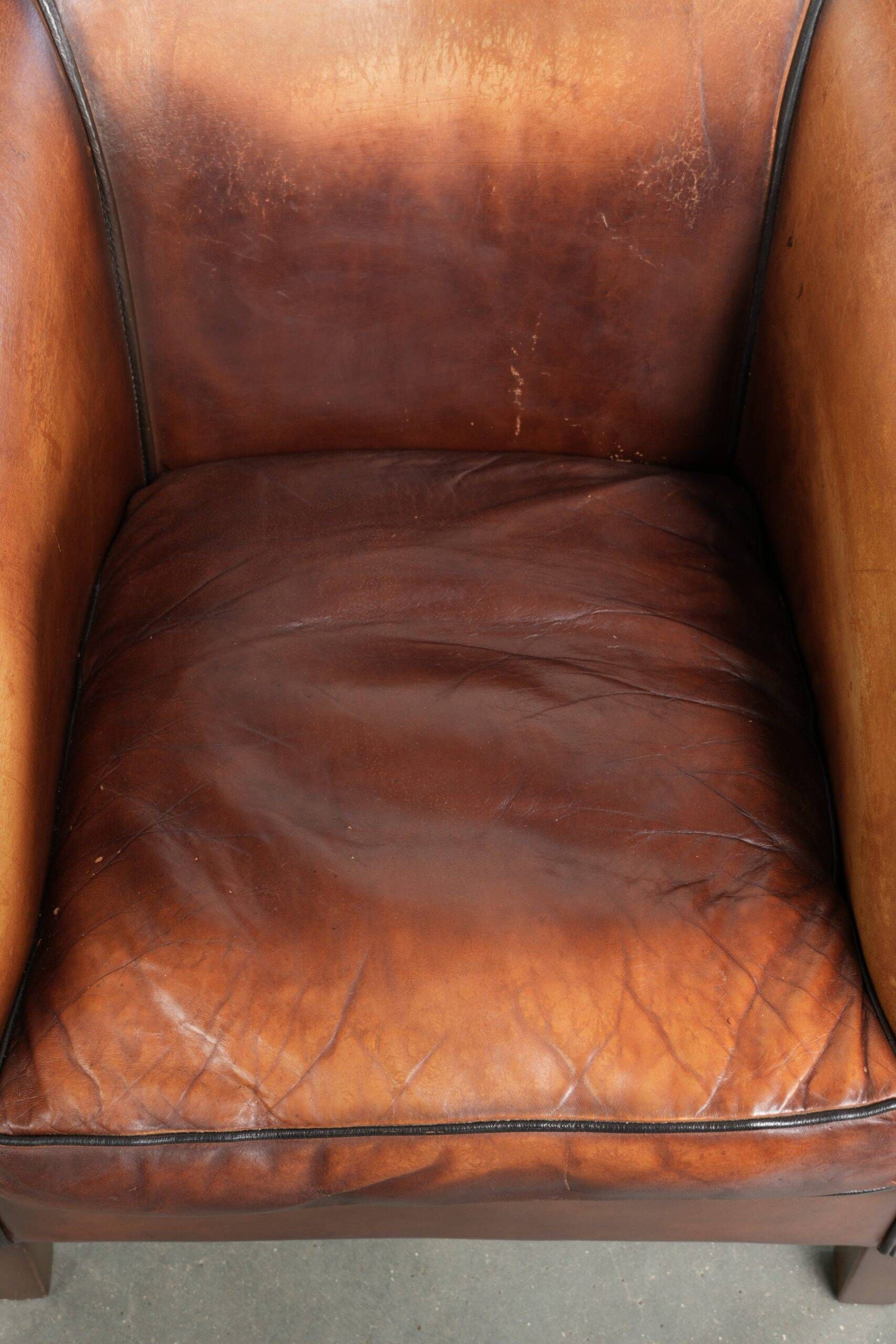 Vintage sheepskin club armchair finished with black piping