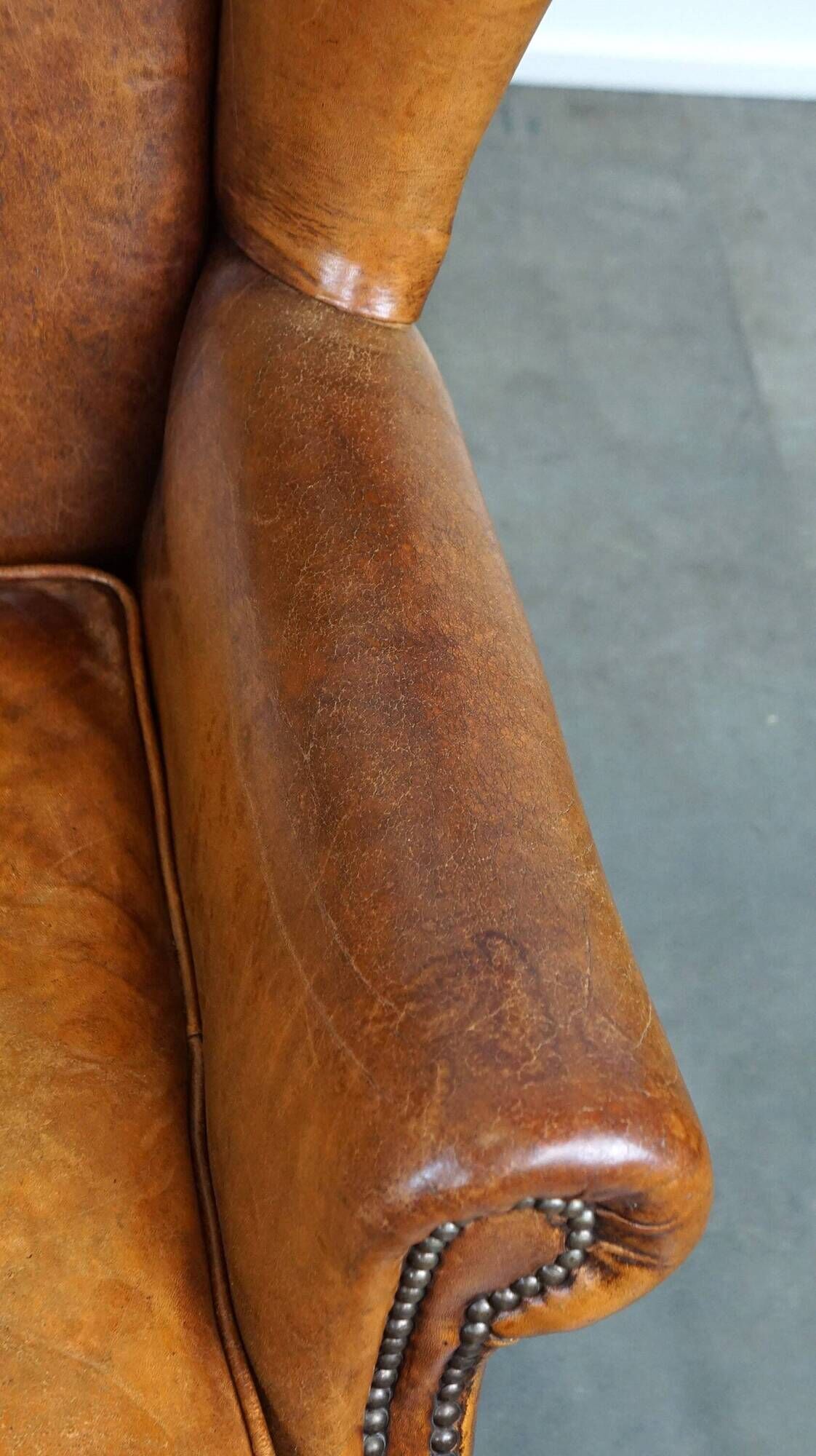 Positively lived-in sheepskin leather wing chair with pleasant seating comfort