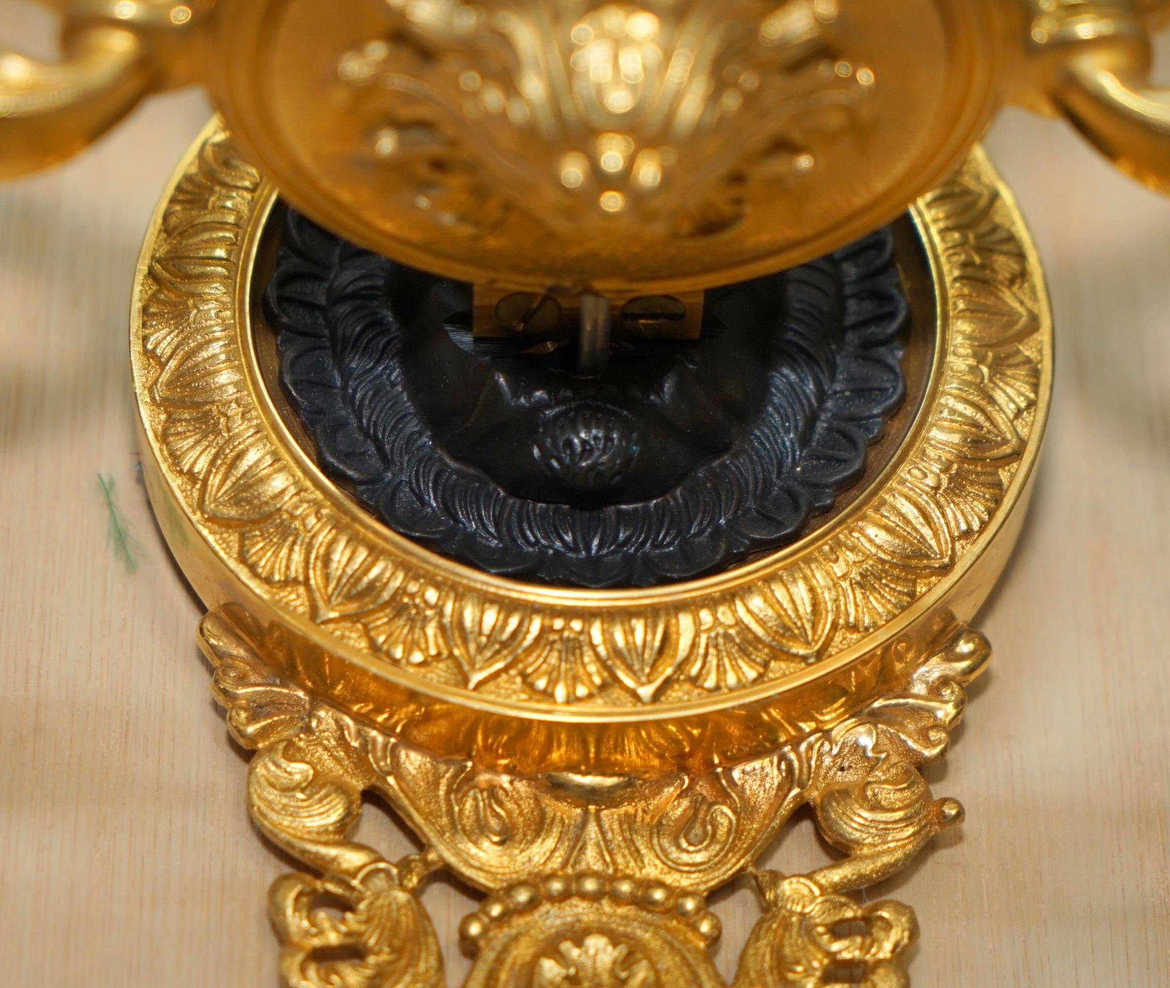 Pair of L'Originale wall sconces plated with 24-carat gold featuring four bronze candles.