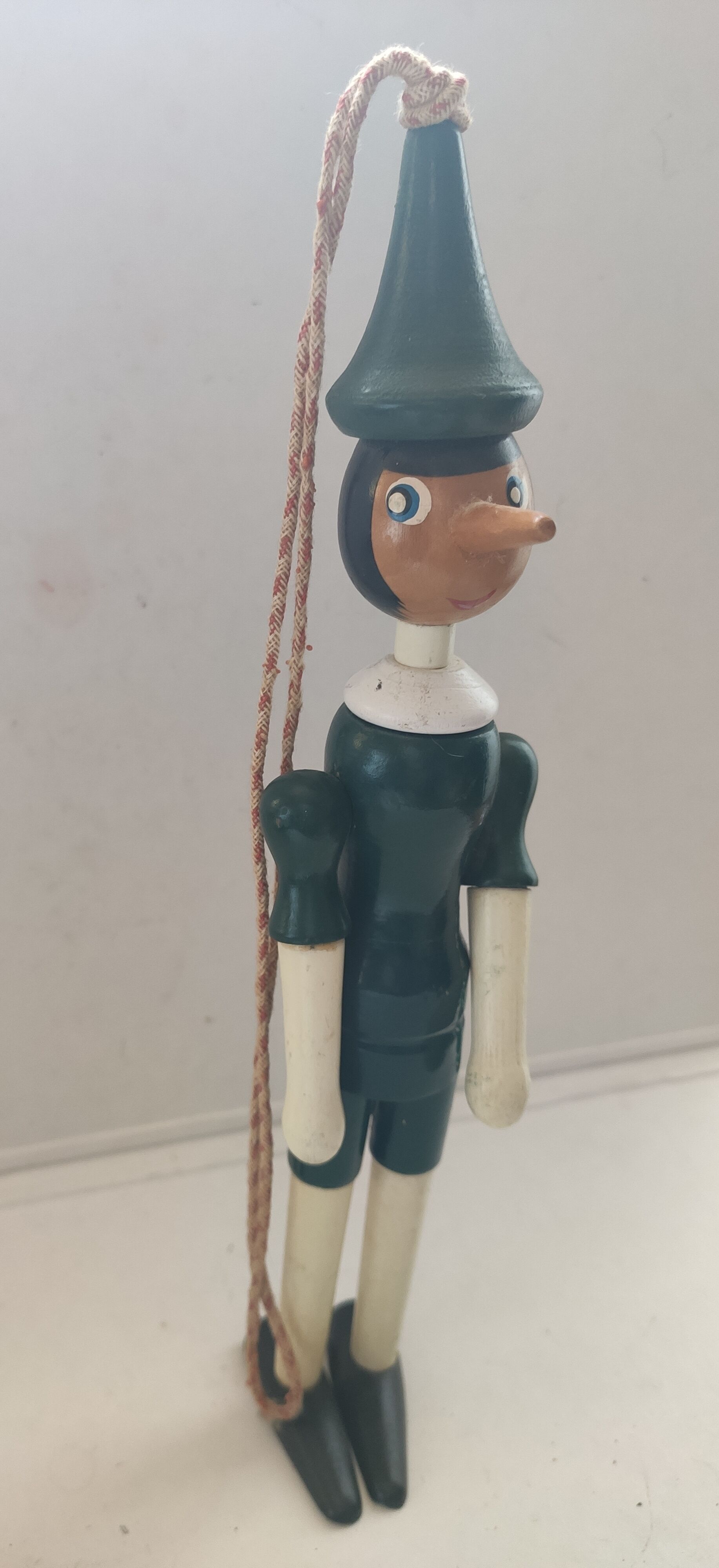 Green pinochio puppet in old wood