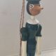Green pinochio puppet in old wood