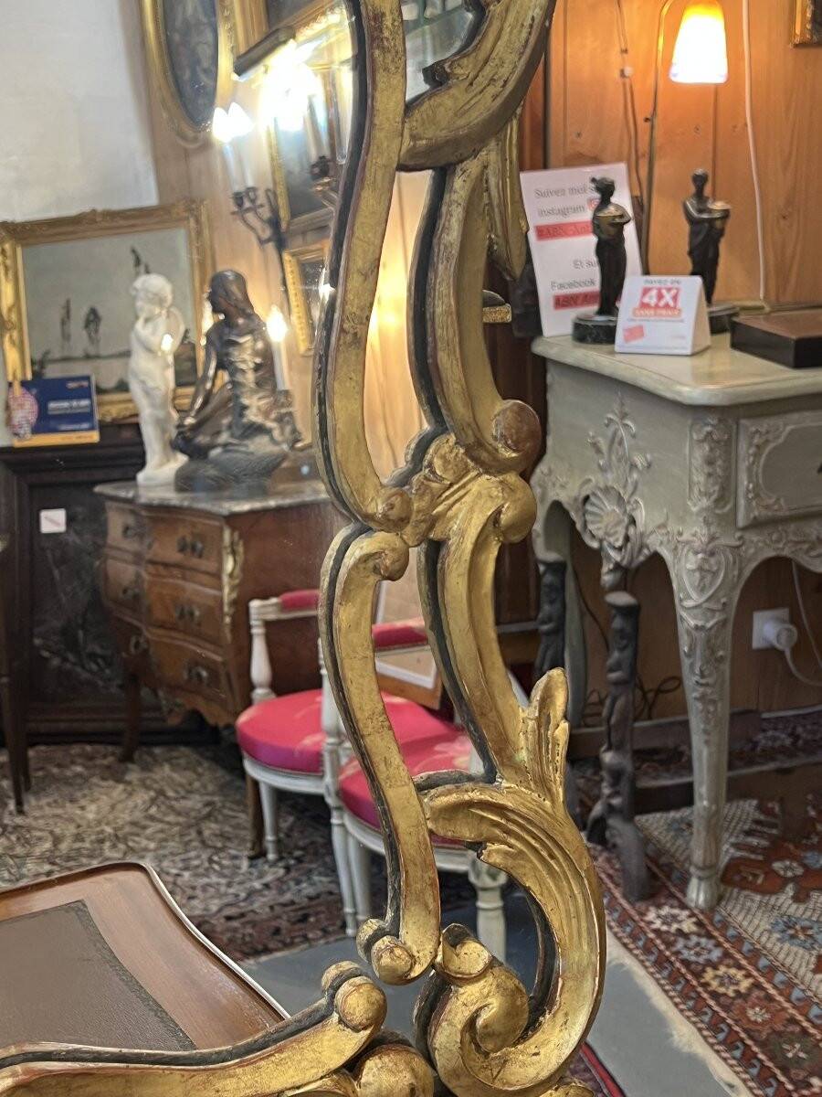 Mirror with carved and gilded wooden frame, 18th century, with scrollwork decoration.