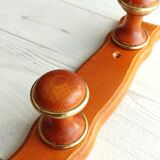 Wall-mounted coat rack in wood and brass