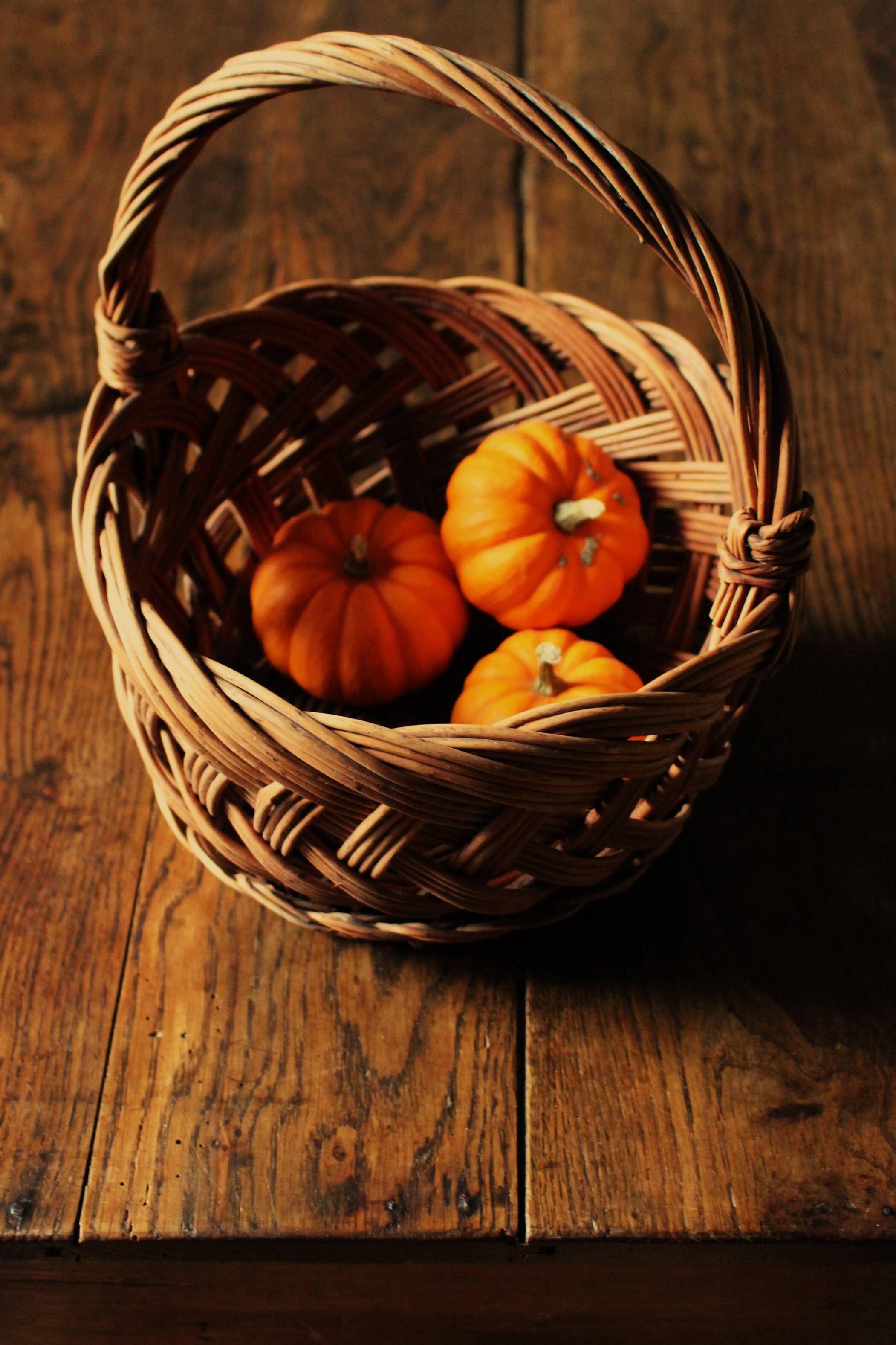Round woven dark wicker basket with openwork vintage handle