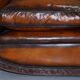 Two-seater canapé in aged leather, Victorian style.