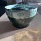 Green cache pot with a foam trim.