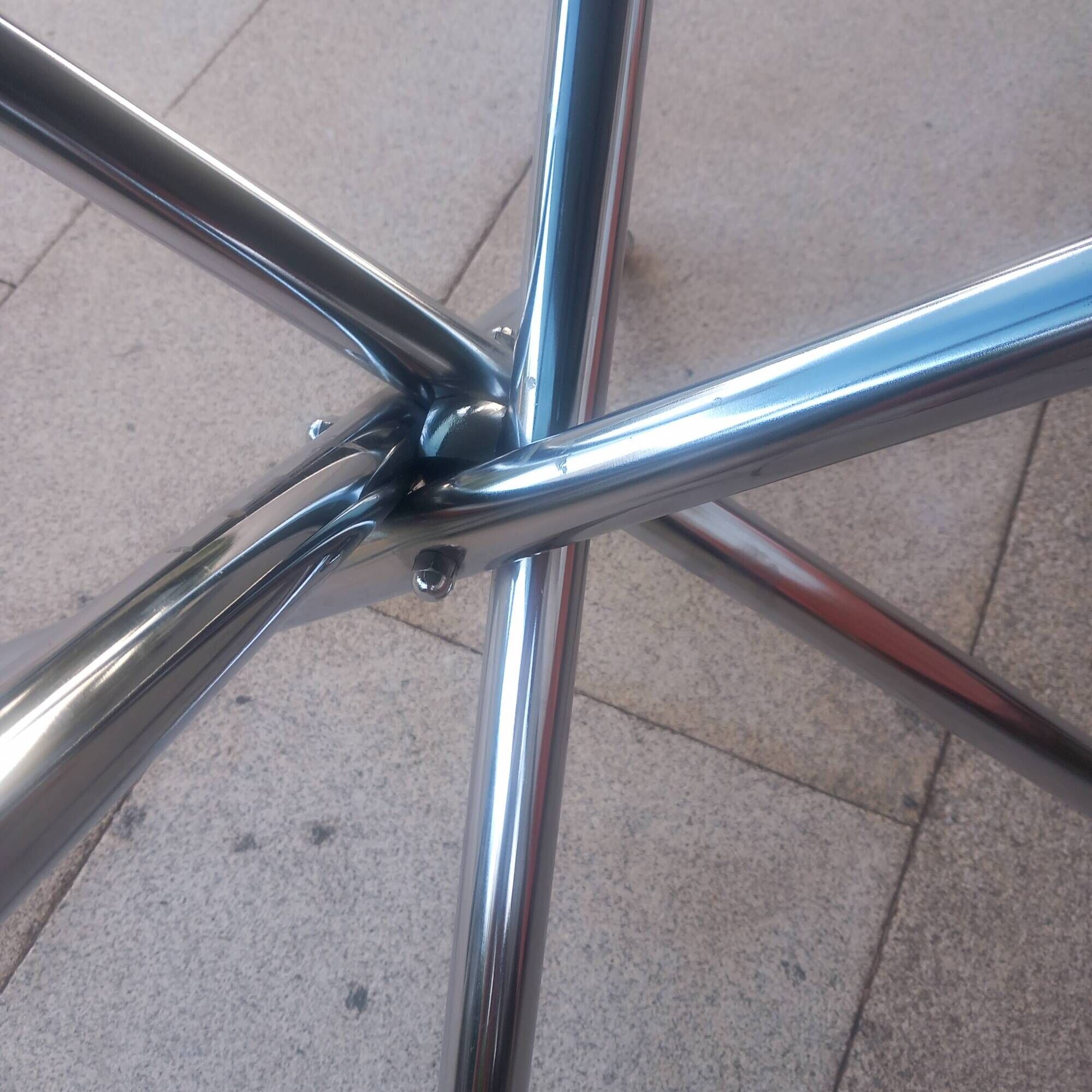 Round smoked glass table from the 70s. Foldable stainless steel legs.