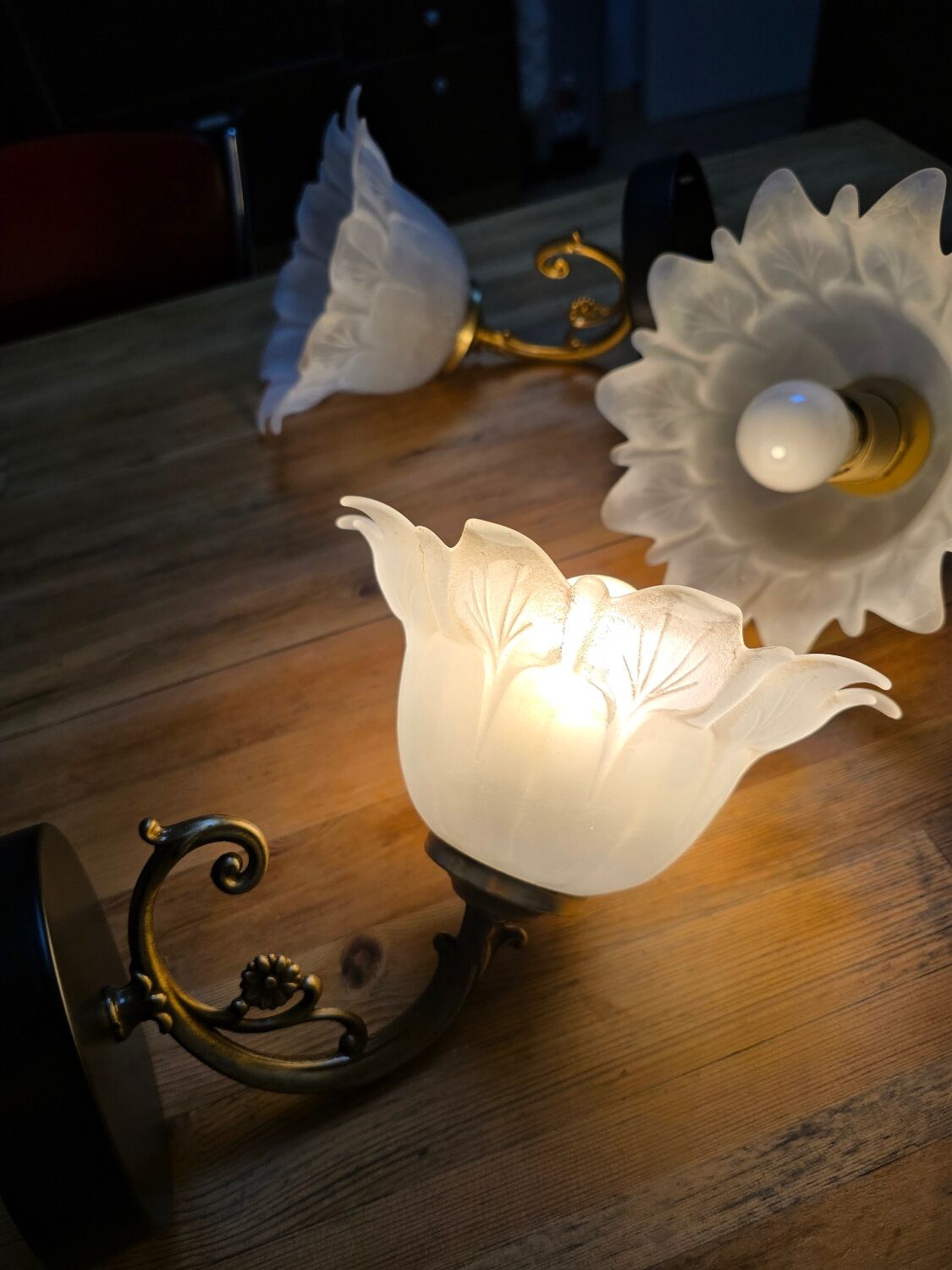 Frosted glass tulip wall sconces with brass arms.